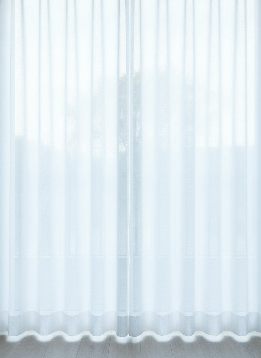 Sheer white voile drawn across a window with strong afternoon sun behind it, which is the entire argument of this page in a single frame. This is what any curtain looks like at two in the afternoon: the colour has washed out to near white, the folds have flattened into faint vertical bands, the weave has become the only visible texture, and a tree outside is readable straight through the cloth as a soft grey silhouette. Nothing that was designed survives. Twelve hours later, with the room lamps on and the darkness outside, the same panel is opaque, saturated and full of shadow. A curtain is not one object, it is two.