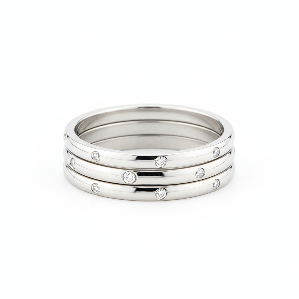 AI jewelry design generator result showing a set of modern minimalist silver stackable rings with tiny diamonds on a white background