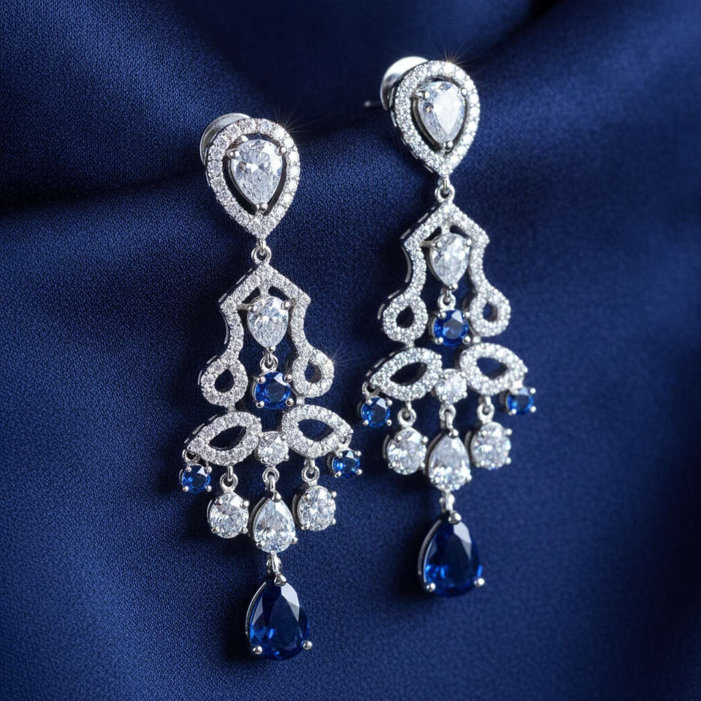 AI jewelry design generator result showing a pair of sapphire and diamond chandelier drop earrings in white gold against navy silk