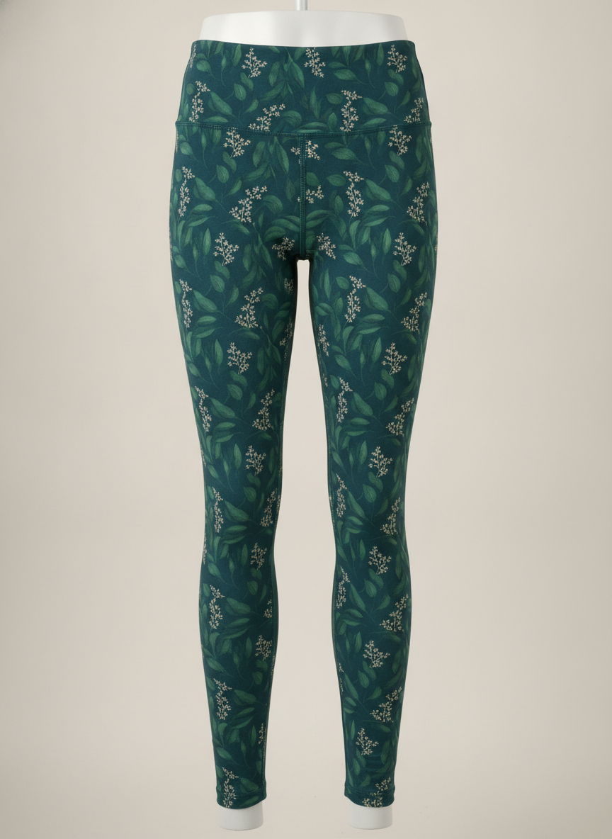 AI leggings design generator result: unbranded high waisted leggings shown front on over a pale studio mannequin, printed all over with a dense repeat of deep green eucalyptus leaves and small cream sprigs on a dark teal ground, the same print carrying across the wide flat waistband